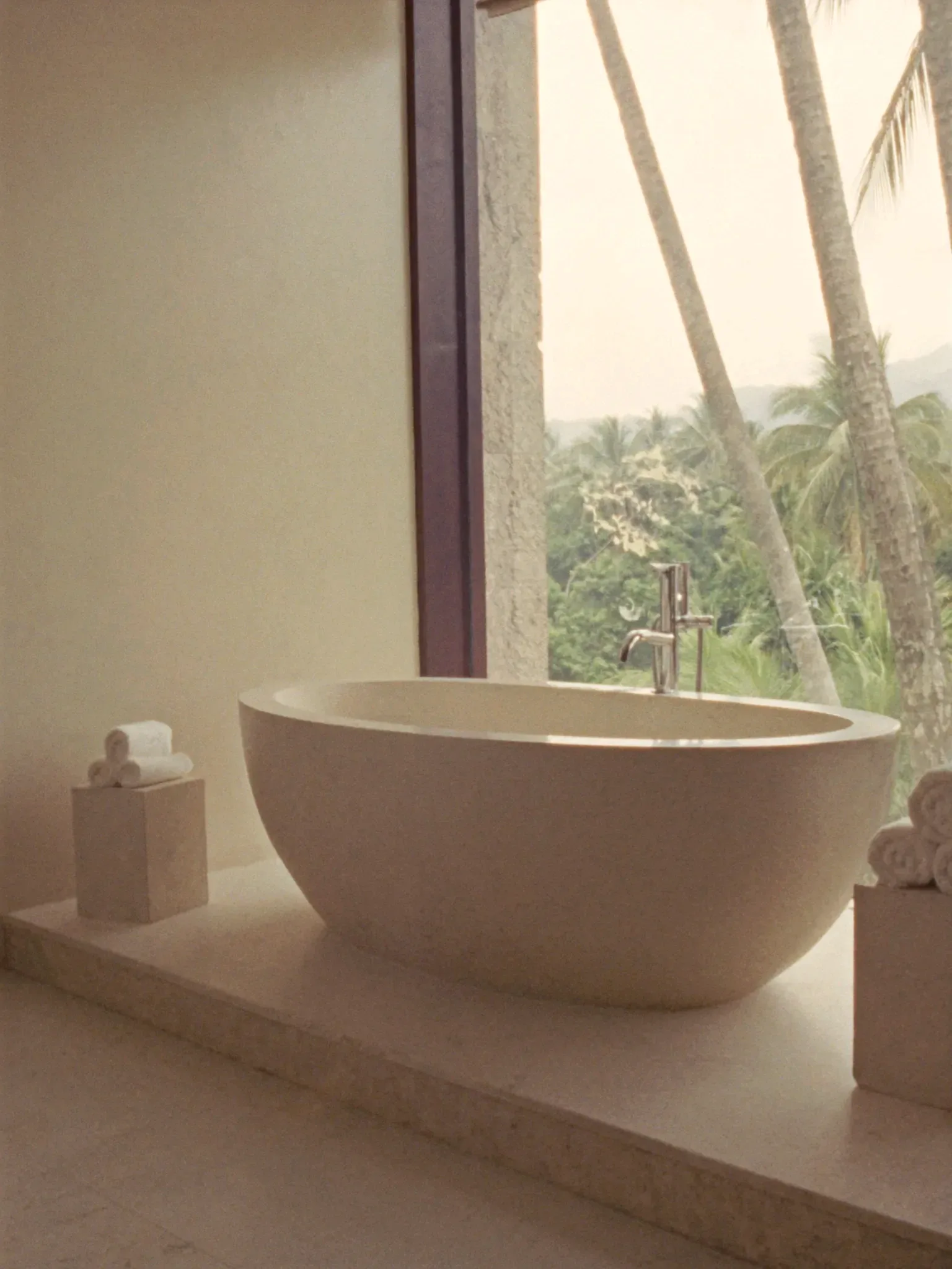 A stone bathtub by a window with a jungle view (placeholder)