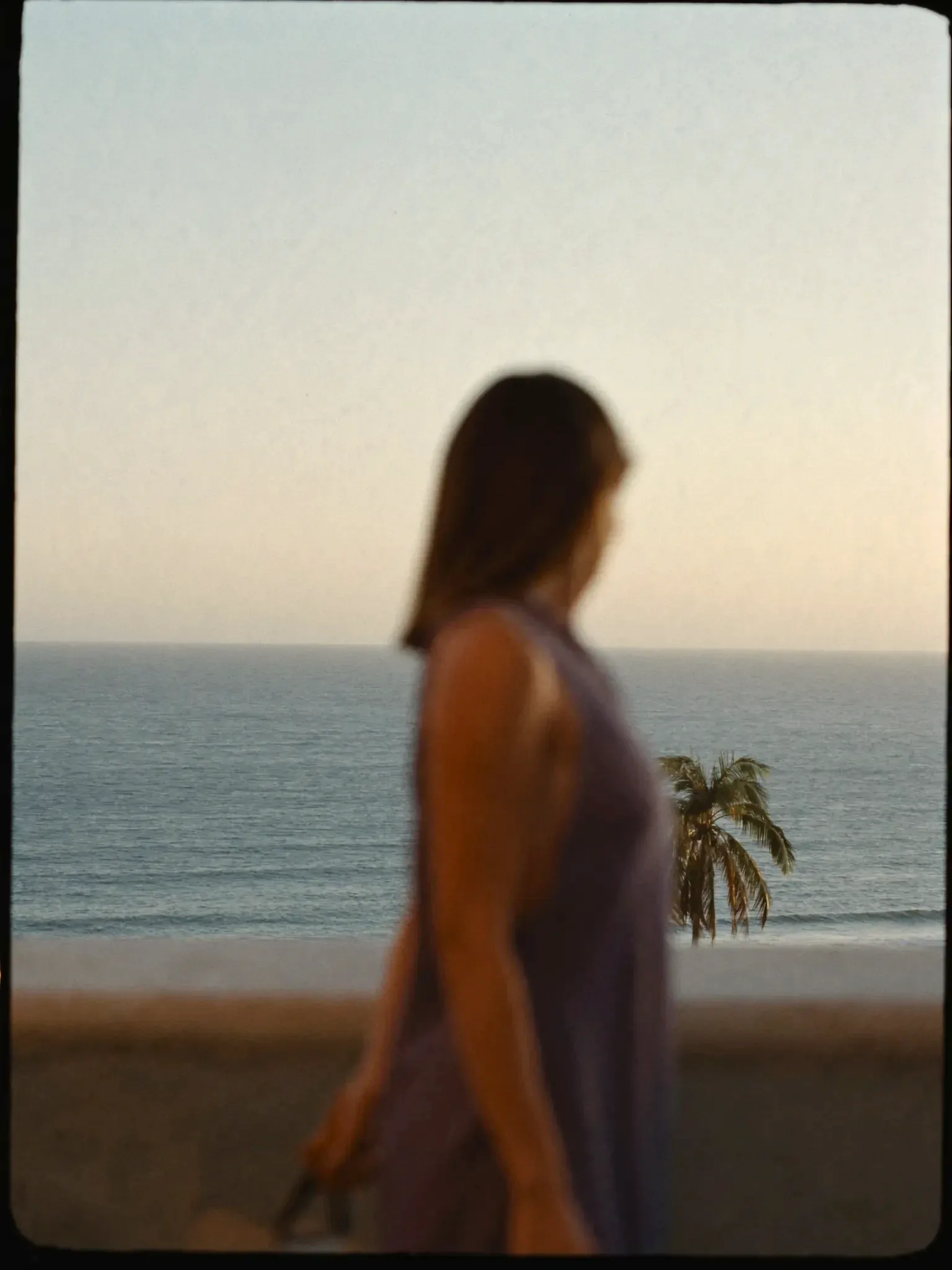 A figure on a terrace, ocean in focus behind (placeholder)